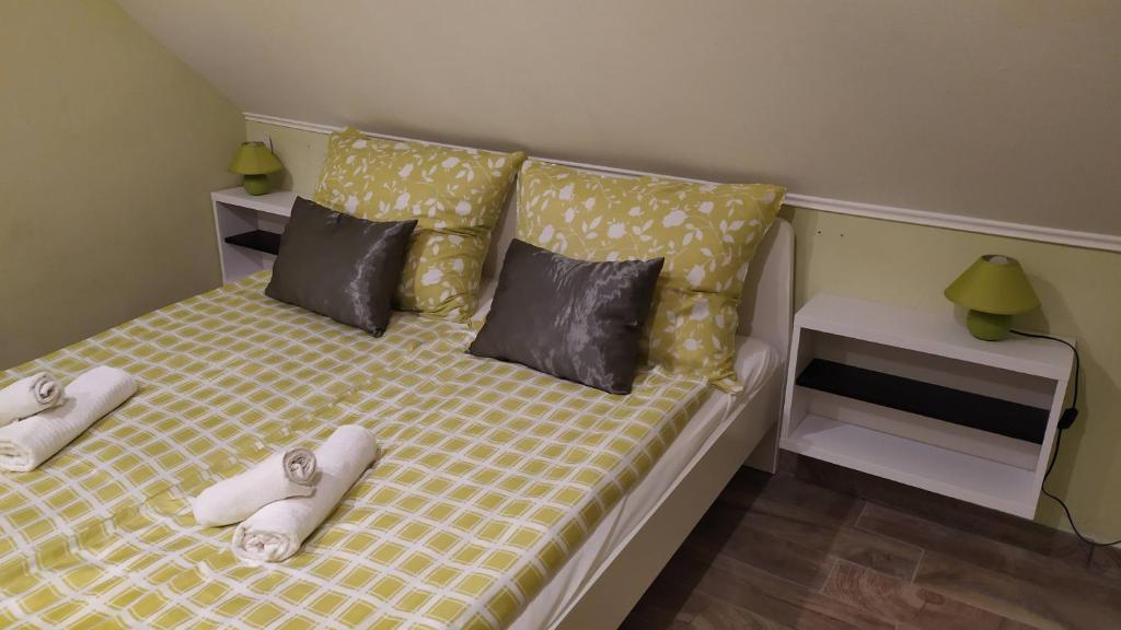 Un dormitorio con una cama con zapatillas. en Arcadia Guesthouse, en Ábrahámhegy