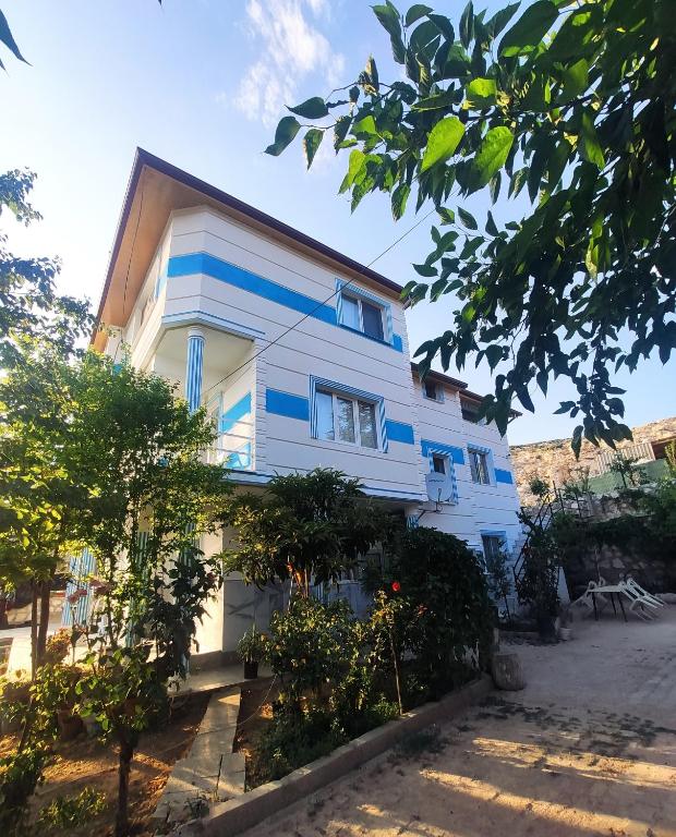 a house with blue and white stripes on it at Kaplan Apart - Pansiyon in Yeşilova