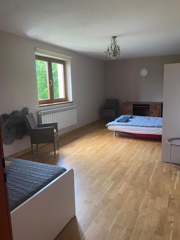 a room with a bedroom with a bed and a wooden floor at Apartament w górach Gorce in Nowy Targ