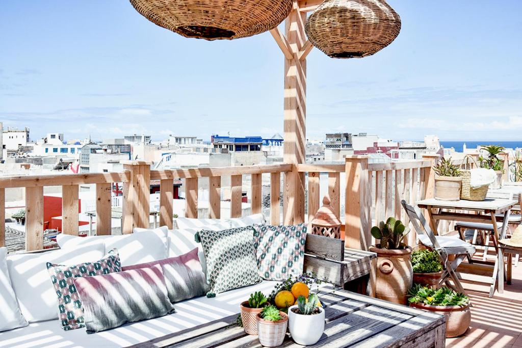 eine Terrasse mit einem Sofa und Obst auf dem Tisch in der Unterkunft Riad Lyon-Mogador in Essaouira