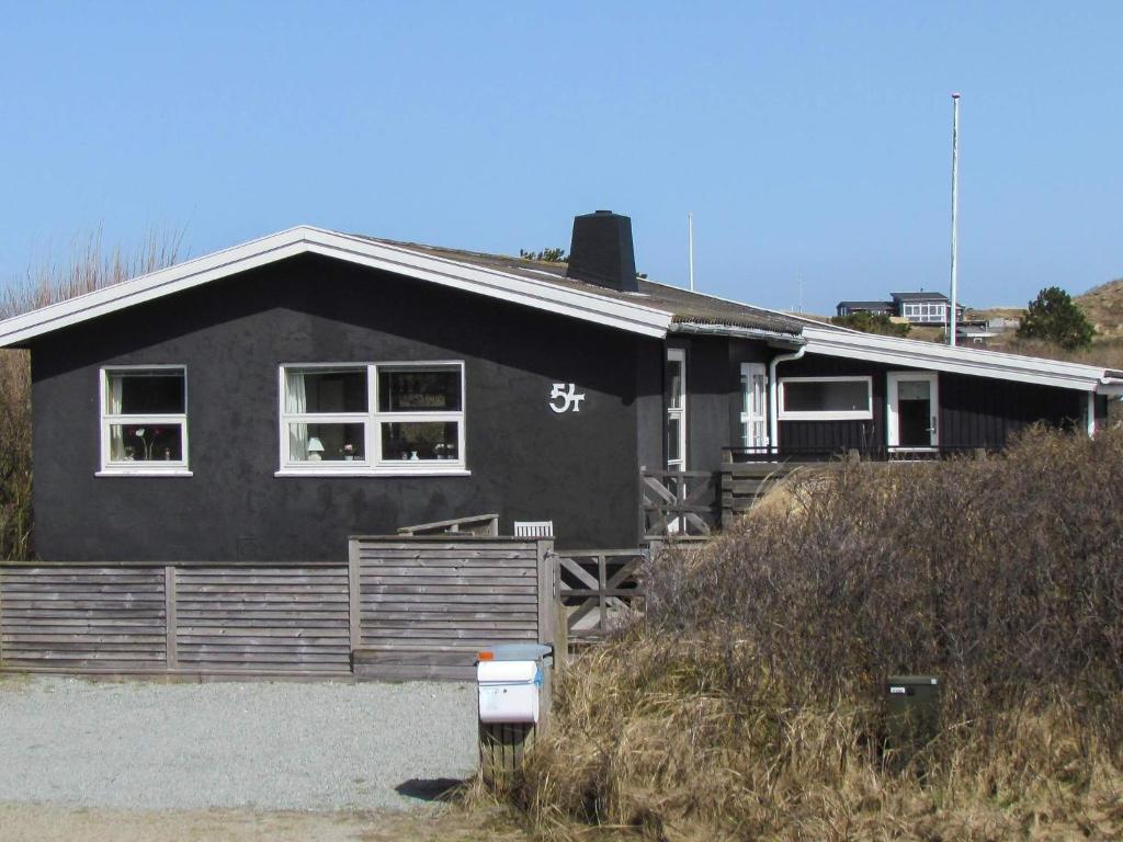 a black house with a sign on the side of it at Holiday home Fanø LXXXVI in Fanø