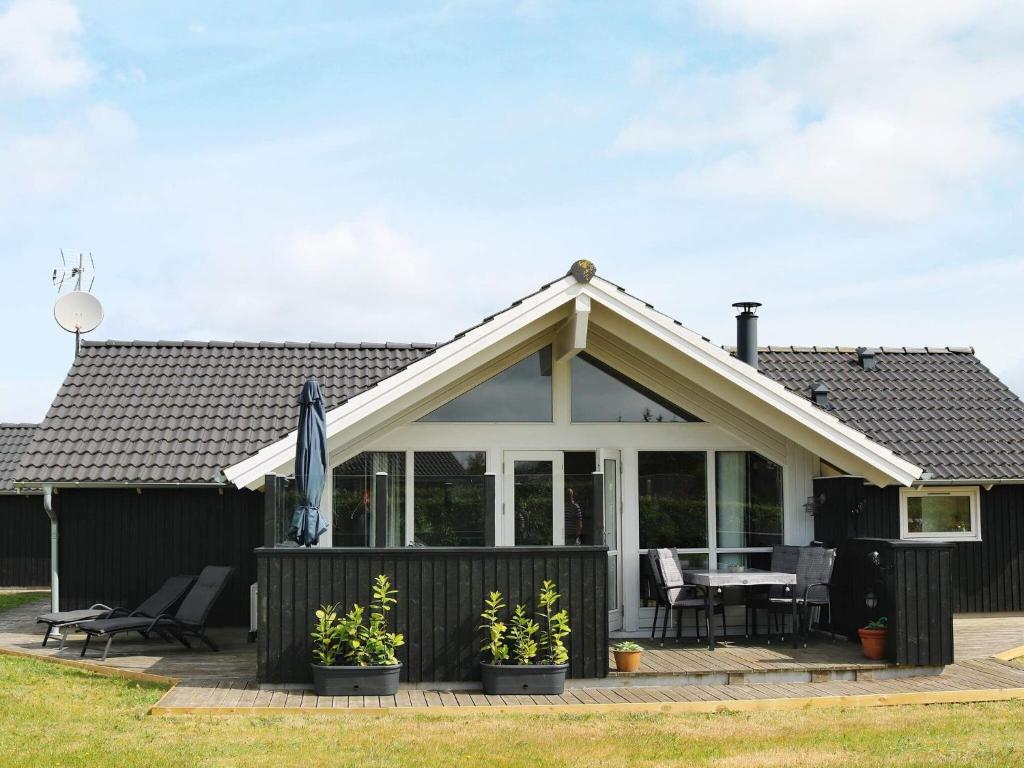 una casa con terrazza arredata con tavolo e sedie di 6 person holiday home in Hadsund a Øster Hurup