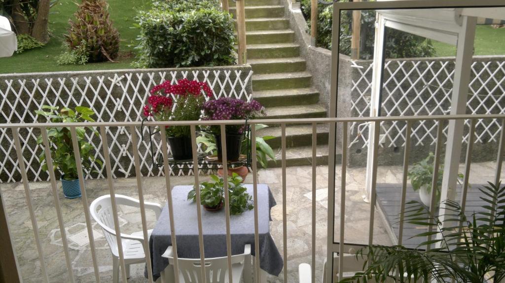 a table with potted plants on a balcony with stairs at Le Conchiglie in Levanto
