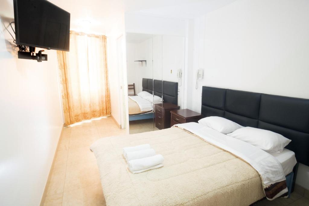 Schlafzimmer mit einem großen Bett mit einem schwarzen Kopfteil in der Unterkunft Hostal Sueños Breña in Lima