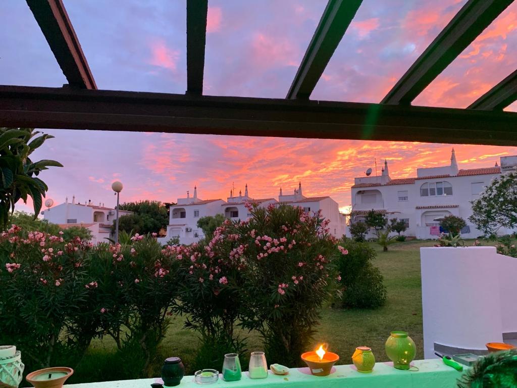 - une vue sur le coucher du soleil depuis la fenêtre d'une maison dans l'établissement Castelo da Esperança na Vila Sra da Rocha, à Porches
