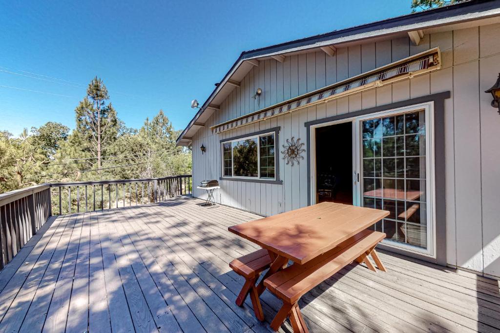 una terraza de madera con una mesa de picnic en una casa en It's Cabin Time, en Groveland