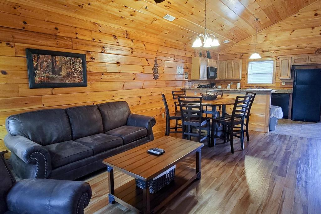 a living room with a couch and tables and a kitchen at Blackberry Bijou in Pigeon Forge