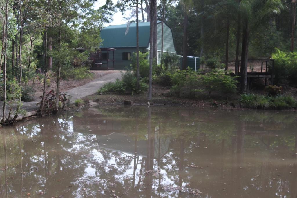 a pool of water in front of a house at LAKE VIEW CHALET 10 minutes to Australia Zoo Landsborough Montville Maleny Caloundra Beaches Glasshouse mountains Big Kart Track in Landsborough