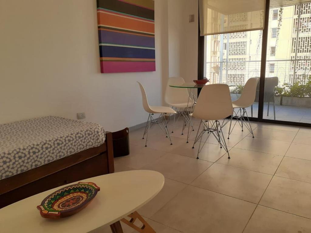 a room with a bed and a table and chairs at Departamento a estrenar in San Miguel de Tucumán