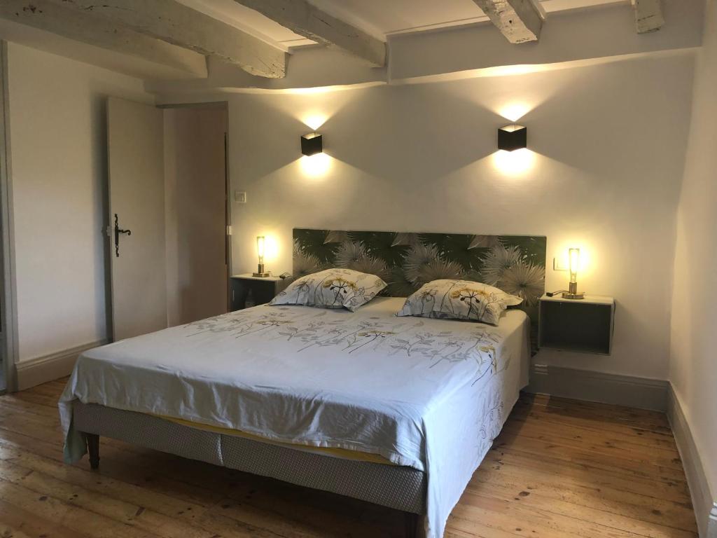 une chambre avec un grand lit blanc avec deux oreillers dans l'établissement Maisonnette quercynoise, à Bétaille