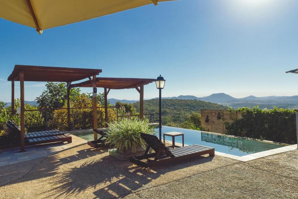 a house with a pool and a view of the mountains at Serra do Juá Pousada de Campo in Pirenópolis