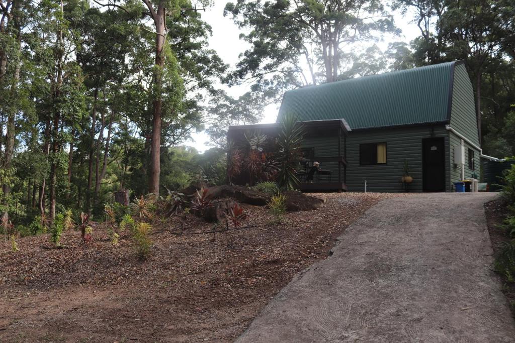 a cabin in the woods with a green roof at LAKE VIEW CHALET 10 minutes to Australia Zoo Landsborough Montville Maleny Caloundra Beaches Glasshouse mountains Big Kart Track in Landsborough