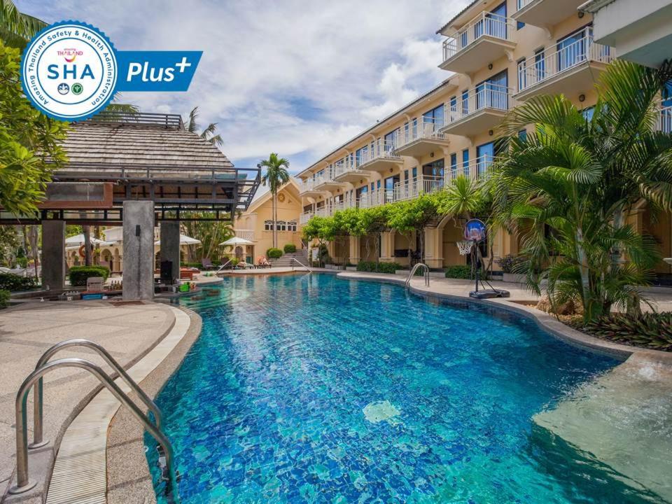 a swimming pool in front of a building at The Front Village - SHA Plus in Karon Beach