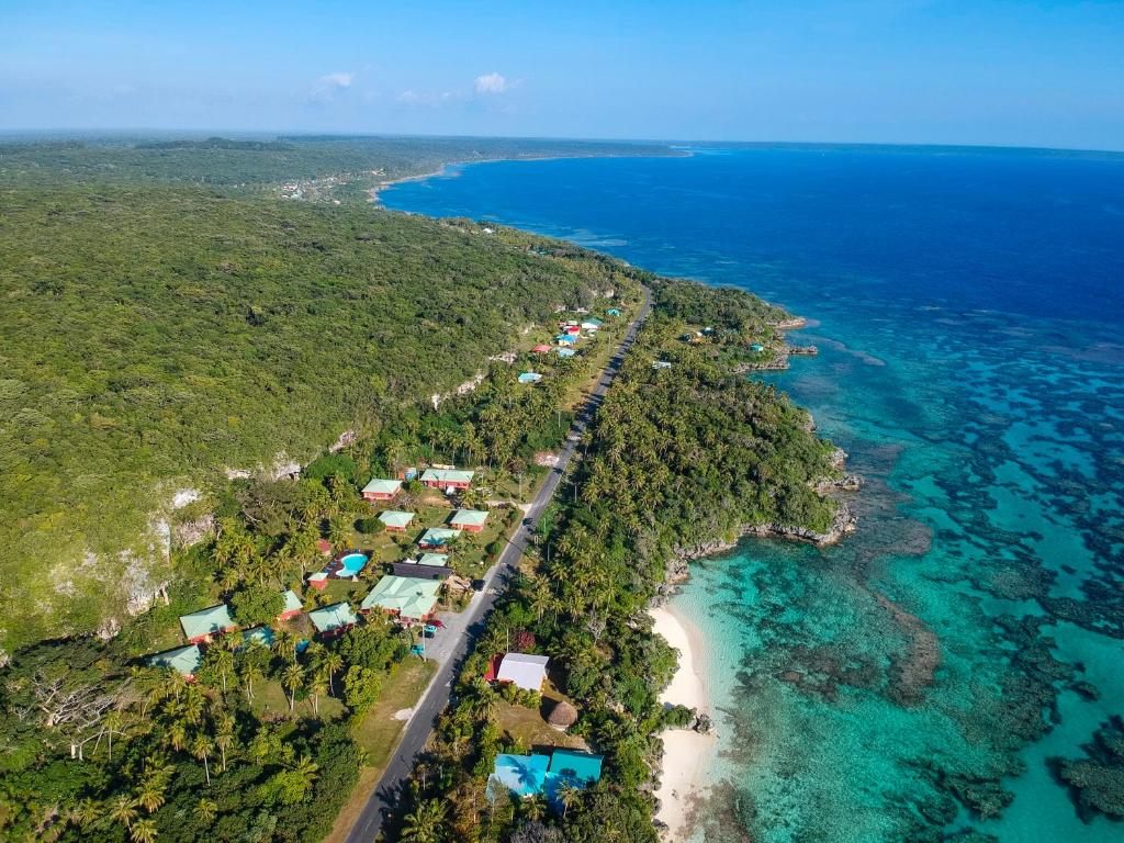 a beach filled with lots of green and yellow umbrellas at Hotel Oasis de Kiamu in Lifou