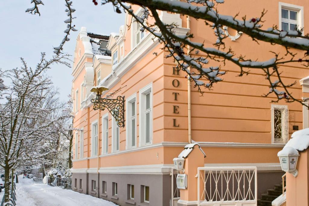 budynek na ulicy z śniegiem na ziemi w obiekcie Hotel Adler w mieście Greifswald