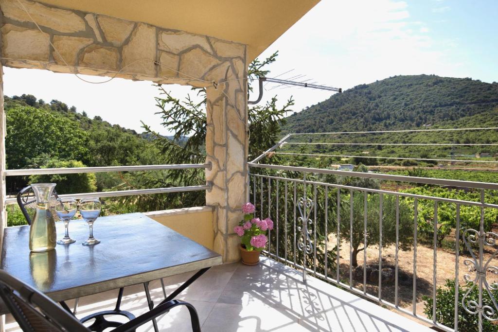 einen Balkon mit einem Tisch und Weingläsern darauf in der Unterkunft Apartment Josipa in Vis