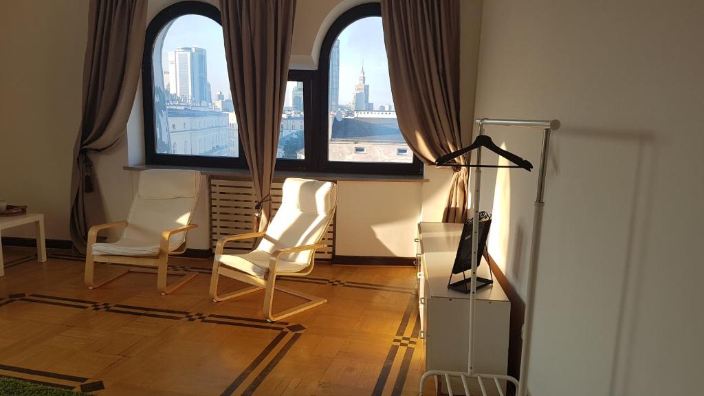 sala de estar con 2 sillas y 2 ventanas en Green Wood Apartament Stara Ochota, en Varsovia