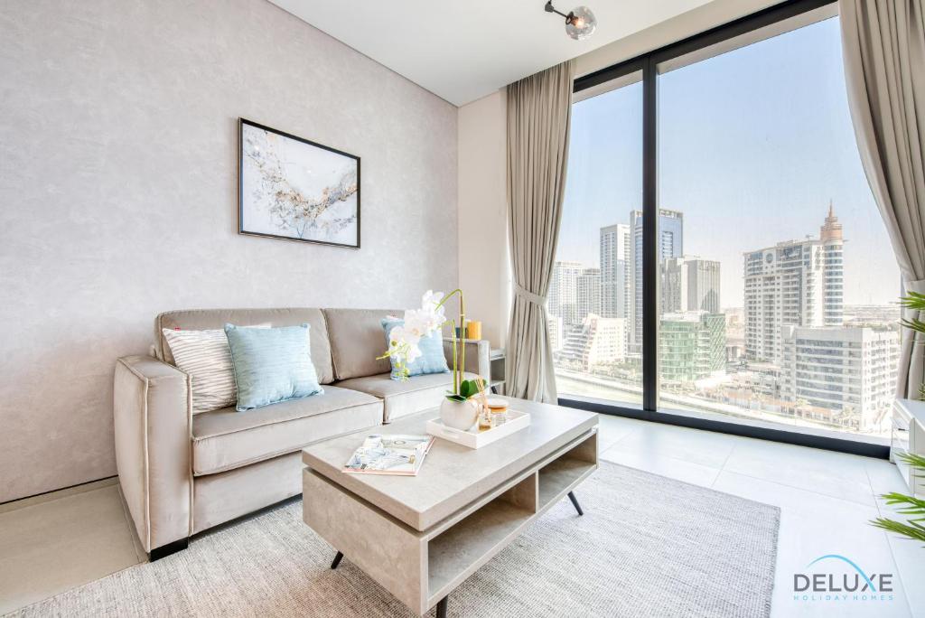 a living room with a couch and a large window at Graceful 1BR at The Address Residences in JBR by Deluxe Holiday Homes in Dubai