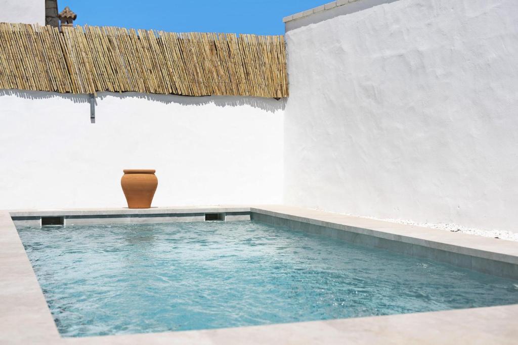 a swimming pool with a vase sitting next to a building at Casa Jaime in Conil de la Frontera