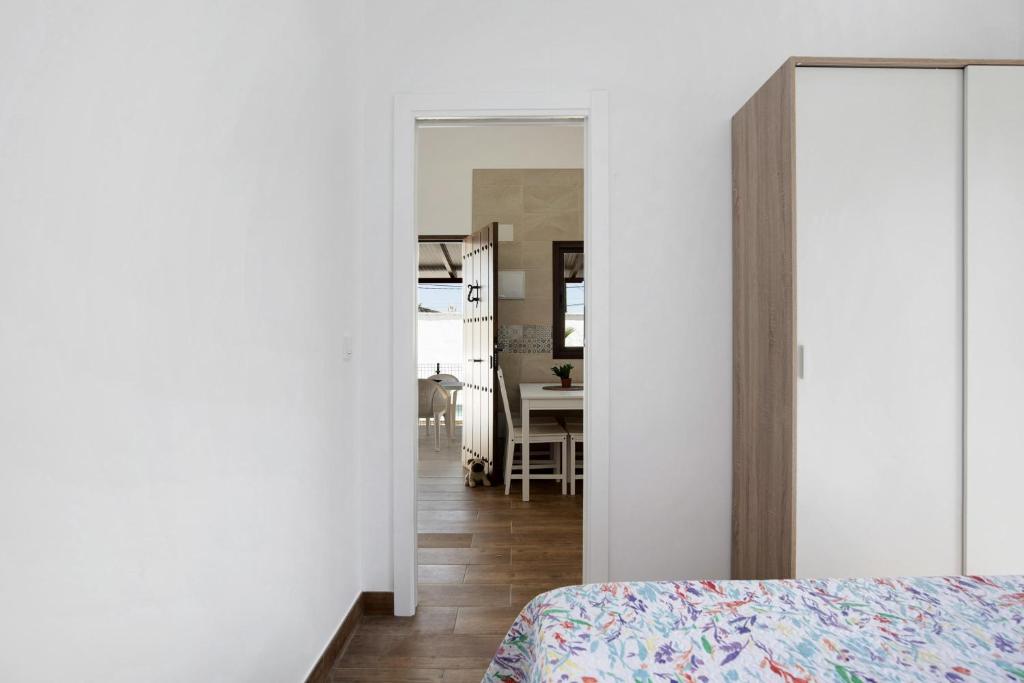 a bedroom with a bed and a dining room at Casa Jaime in Conil de la Frontera