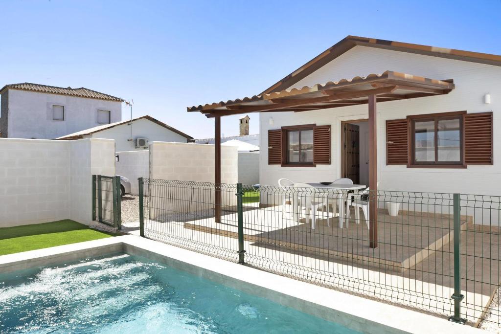 um quintal com uma piscina e uma casa em Casa Jaime em Conil de la Frontera