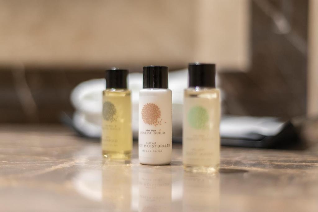 three bottles of moisturizers sitting on a table at Gardino Hotel & Residence in Riyadh