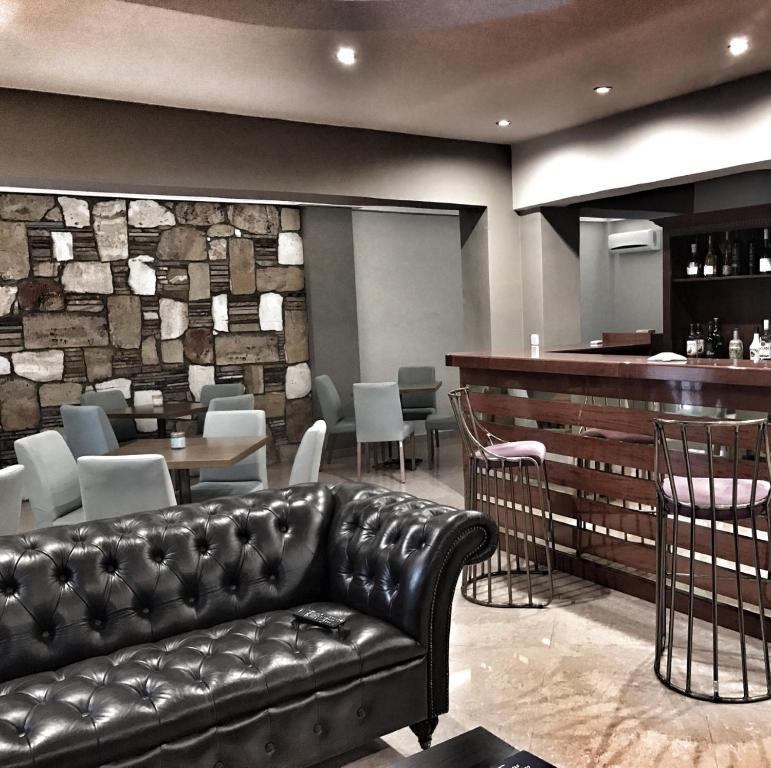 un canapé en cuir dans un restaurant avec un bar dans l'établissement Hotel Kastri, à Loutra Edipsou