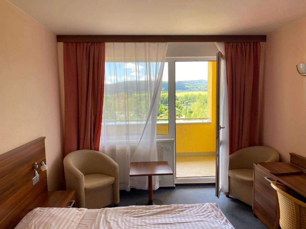 um quarto de hotel com uma cama e uma janela em Apartmány wellness Frymburk em Frymburk