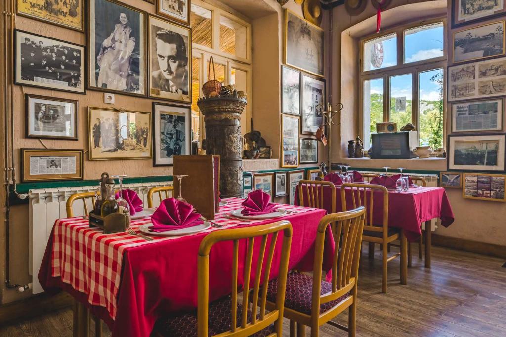 een restaurant met tafels en stoelen met roze tafelkleden bij Hotel Pelikan in Virpazar