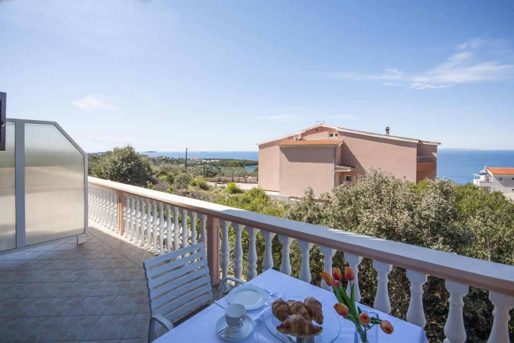 - une table sur un balcon avec vue sur l'océan dans l'établissement Apartments & Rooms Mikelin, à Primošten