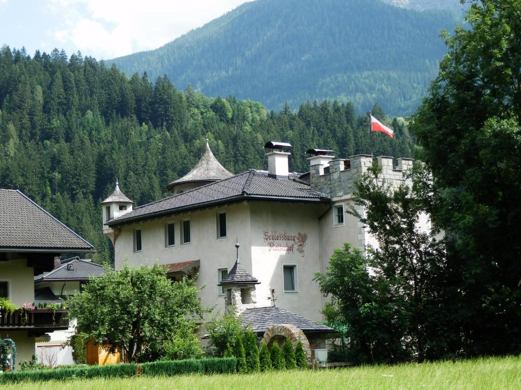 a large white building with a flag on top of it at Schloßburg Reiserhof in Zell am Ziller