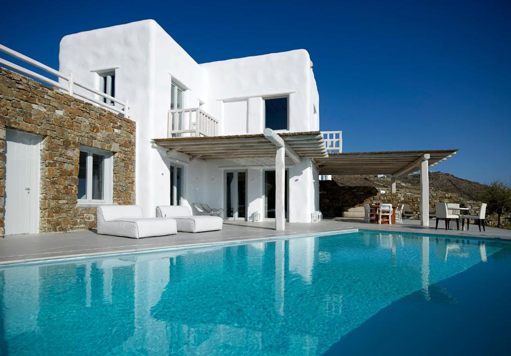 a villa with a swimming pool in front of a house at Ammos Villas in Fanari
