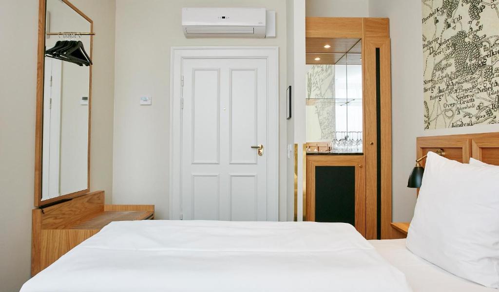 Postel nebo postele na pokoji v ubytování Jørgensens Hotel