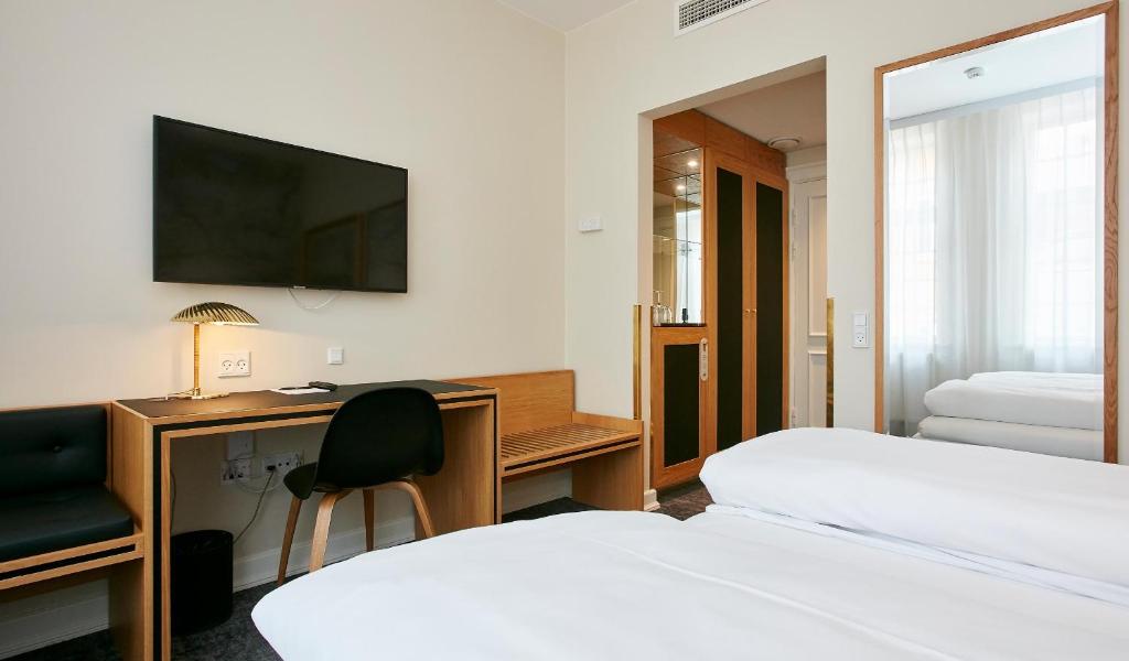 Postel nebo postele na pokoji v ubytování Jørgensens Hotel