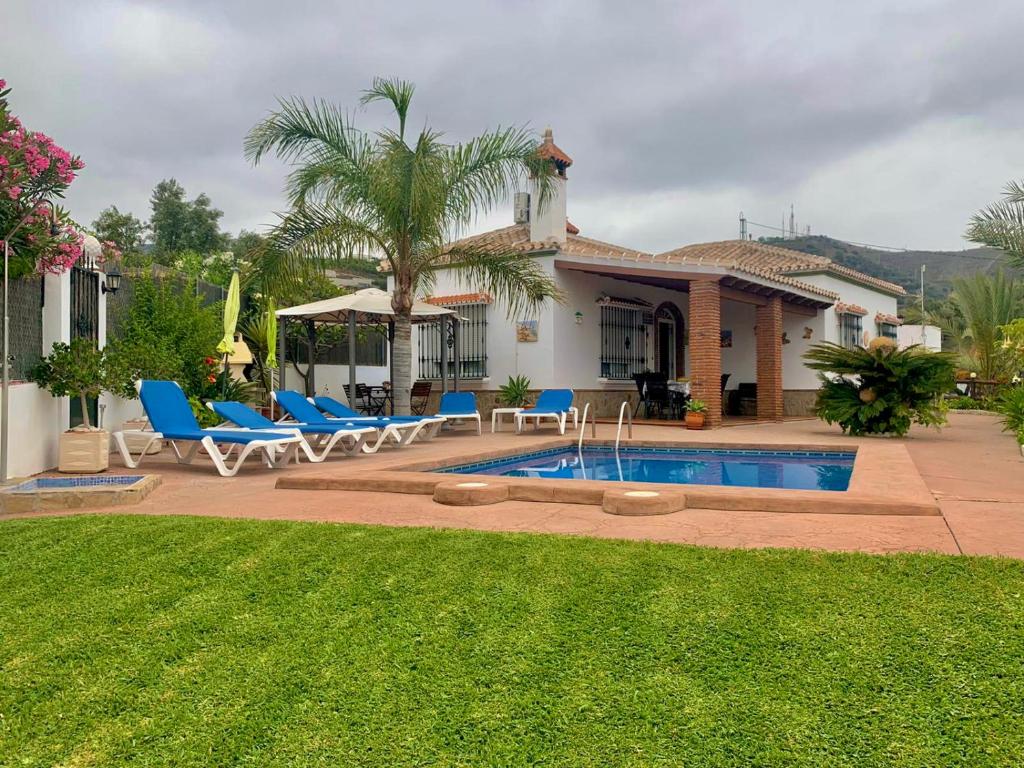 a house with a swimming pool in front of a yard at Cortijo VILLA EL PINO in Torrox