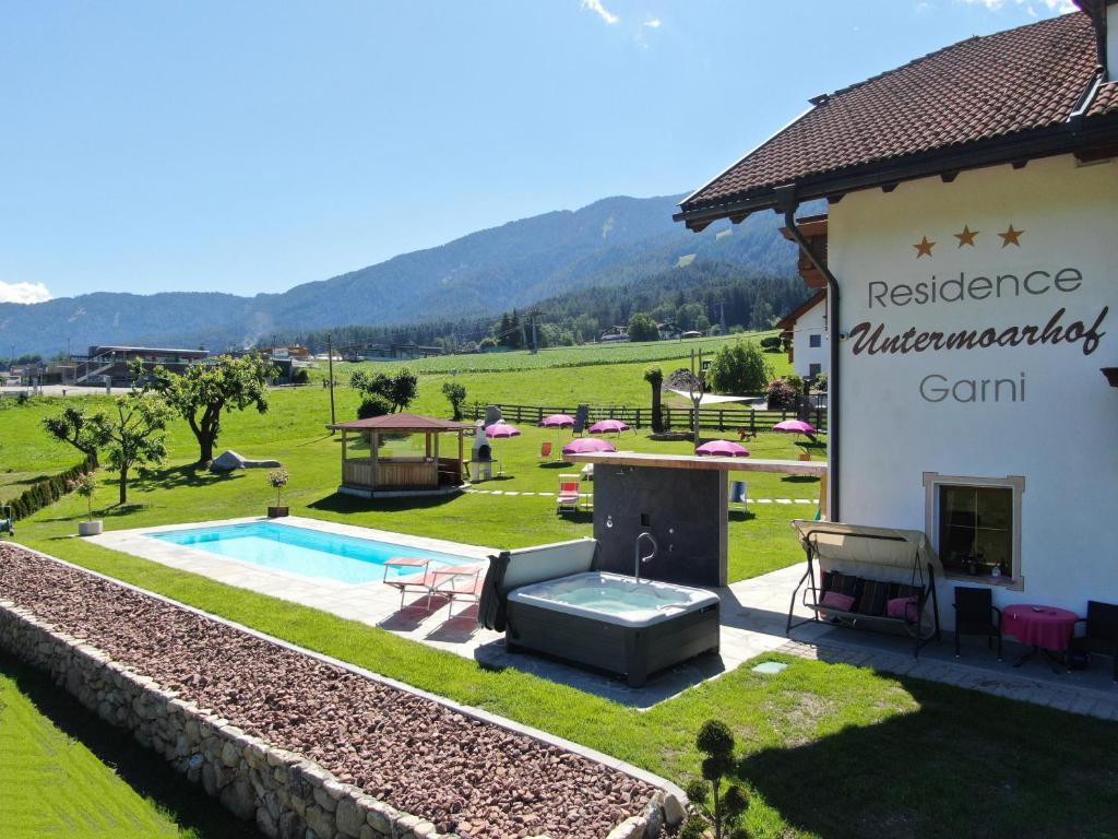 a villa with a swimming pool and a building at Residence Untermoarhof in Brunico