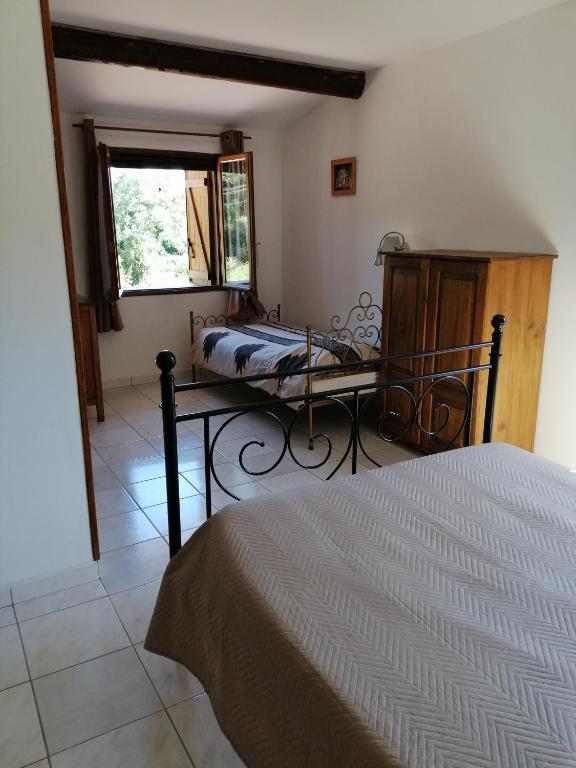 a bedroom with a bed and a window at Sarrola-Carcopino Gîte en Pierre in Sarrola-Carcopino