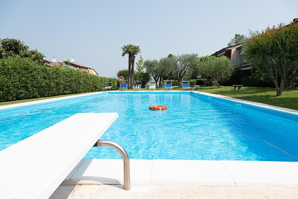 a large blue swimming pool with at APARTMENT ORTENSIA - Regarda Travel in Lazise