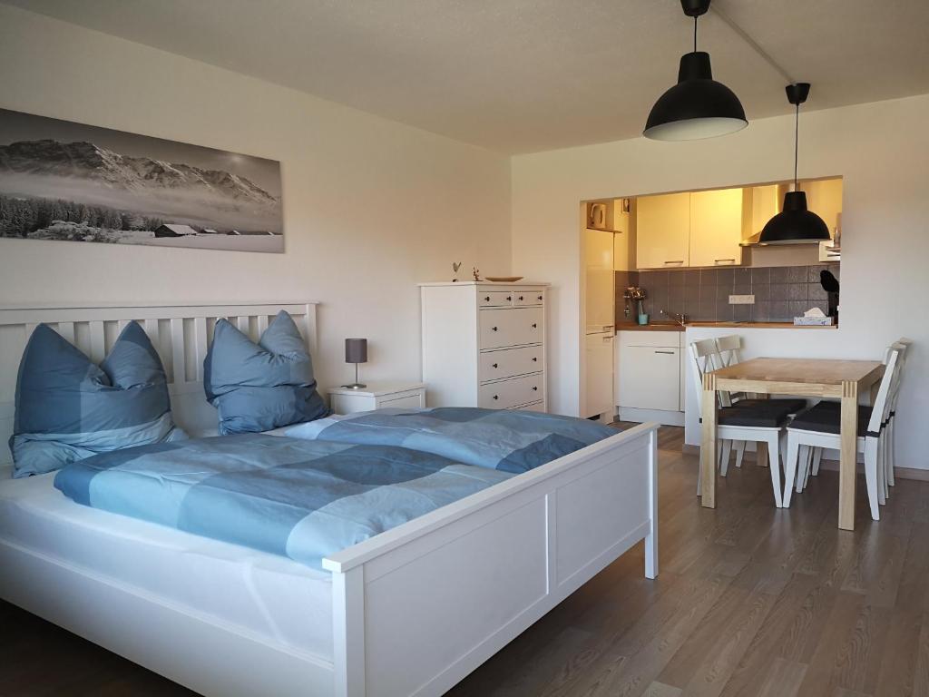 a bedroom with a bed and a table and a kitchen at Ferienwohnung Alpenspaß in Missen-Wilhams