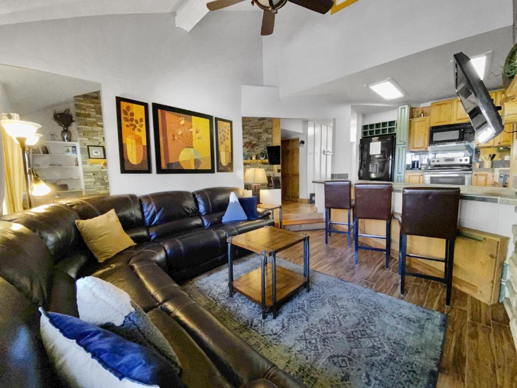 Una sala de estar con un sofá de cuero y una cocina. en Powder Ridge 209 condo, en Breckenridge