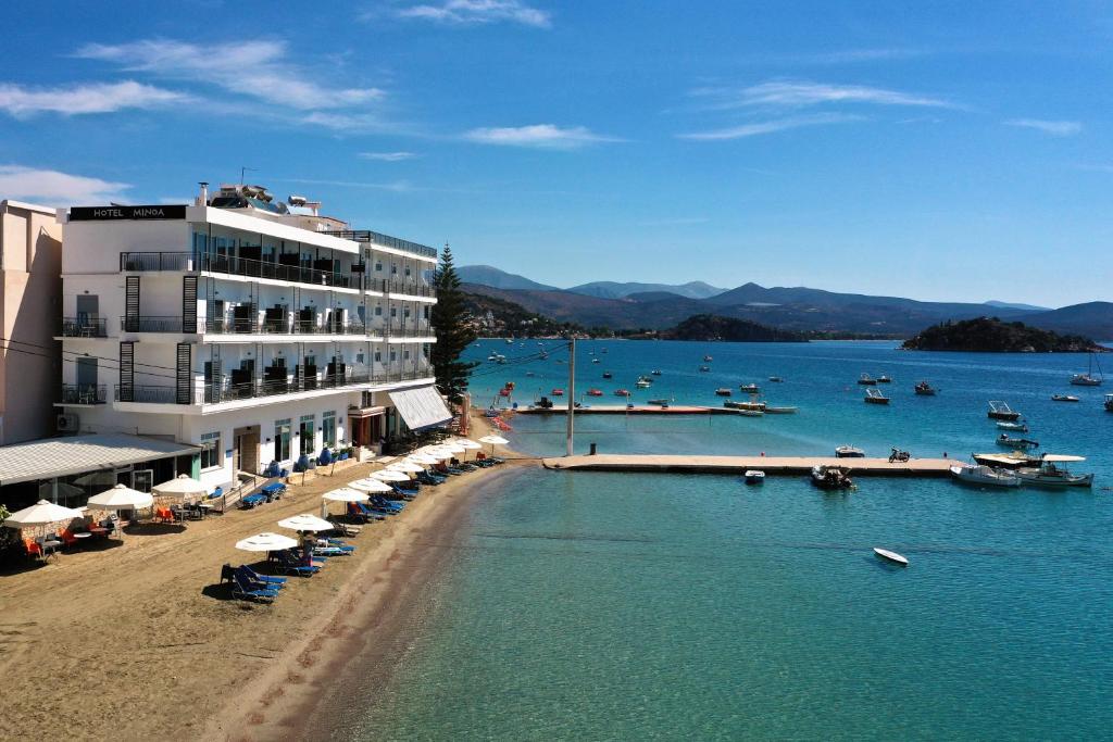 un hotel en la playa con una playa con barcos en el agua en Minoa Hotel, en Tolo