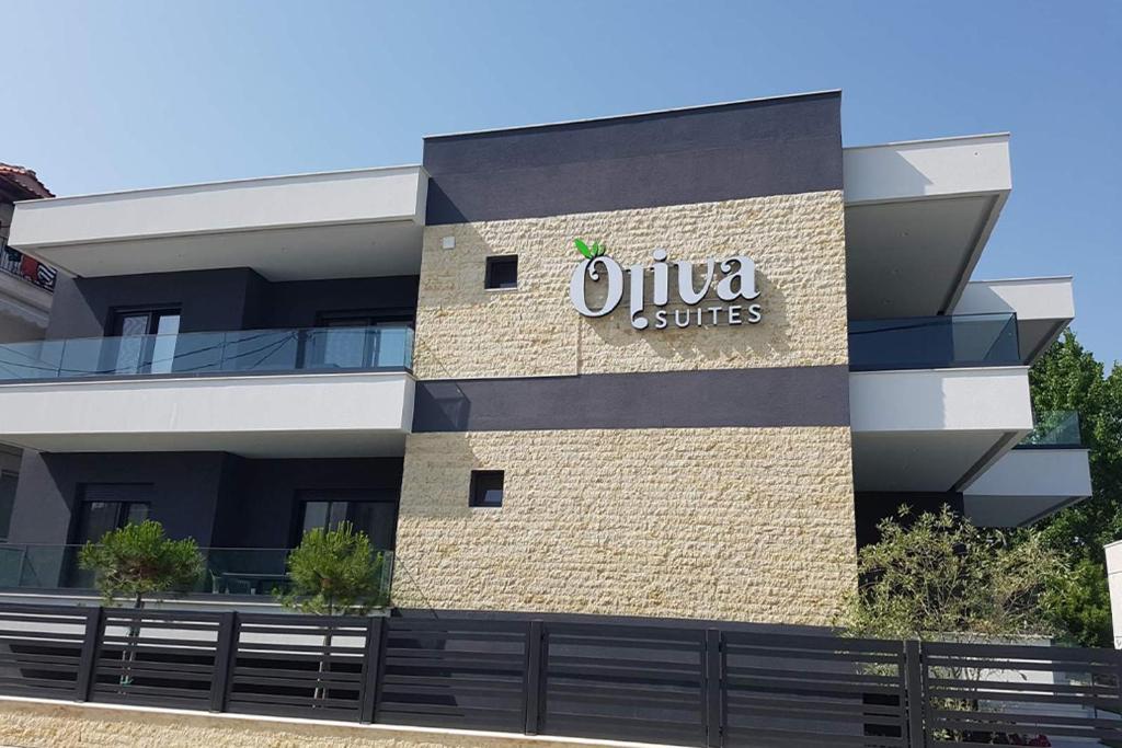 a building with a sign on the side of it at Oliva Suites in Keramotí