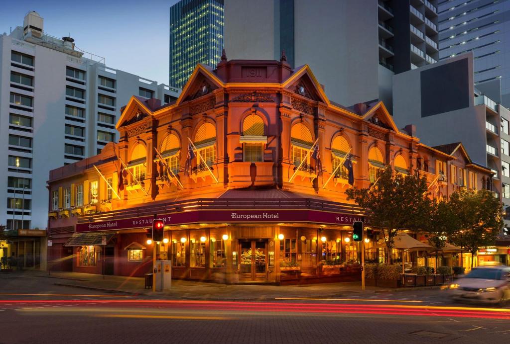 um edifício iluminado na esquina de uma rua em European Hotel em Perth