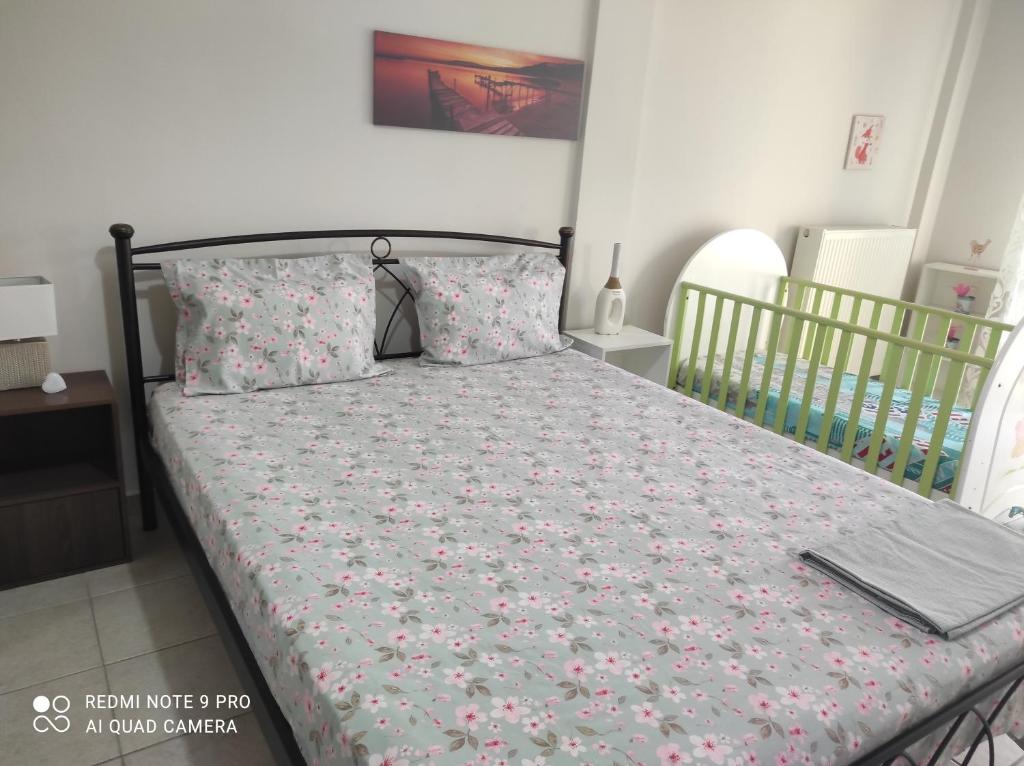 a bedroom with a bed with a floral bedspread and pillows at Melina΄s apartment in Serres