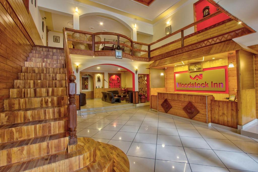 un vestíbulo de un restaurante con una escalera en un edificio en Woodstock Inn Manali, en Manali