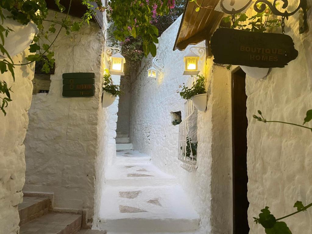 eine Gasse mit weißen Wänden und Lichtern und einem Schild in der Unterkunft 8 oDa Marmaris in Marmaris