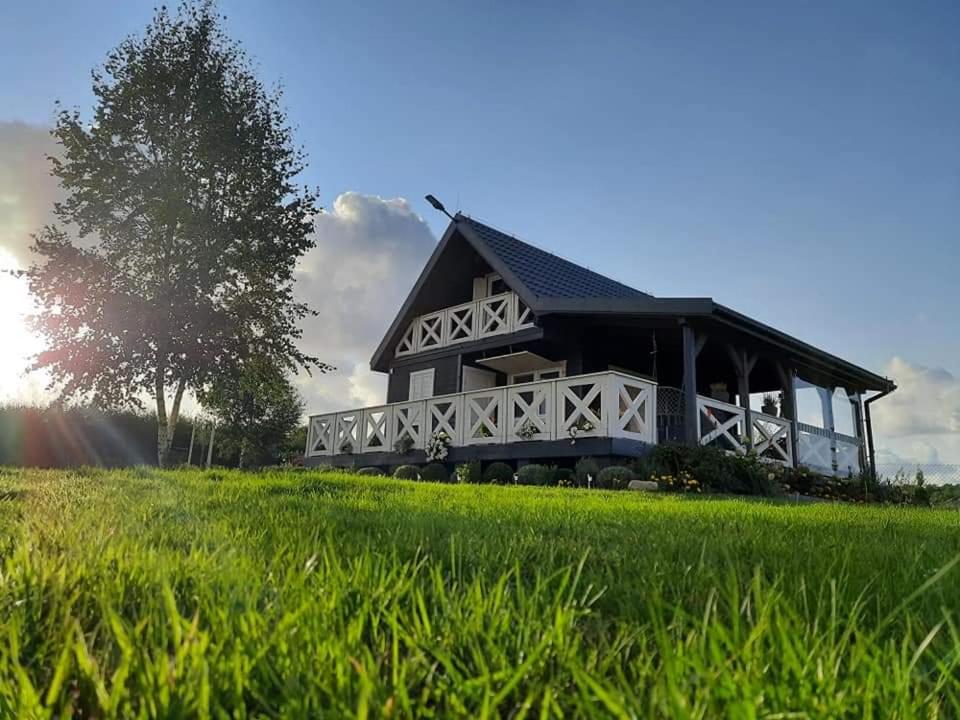 a black and white house in a field of grass at Domek Lawendowe Wzgórze in Mielenko