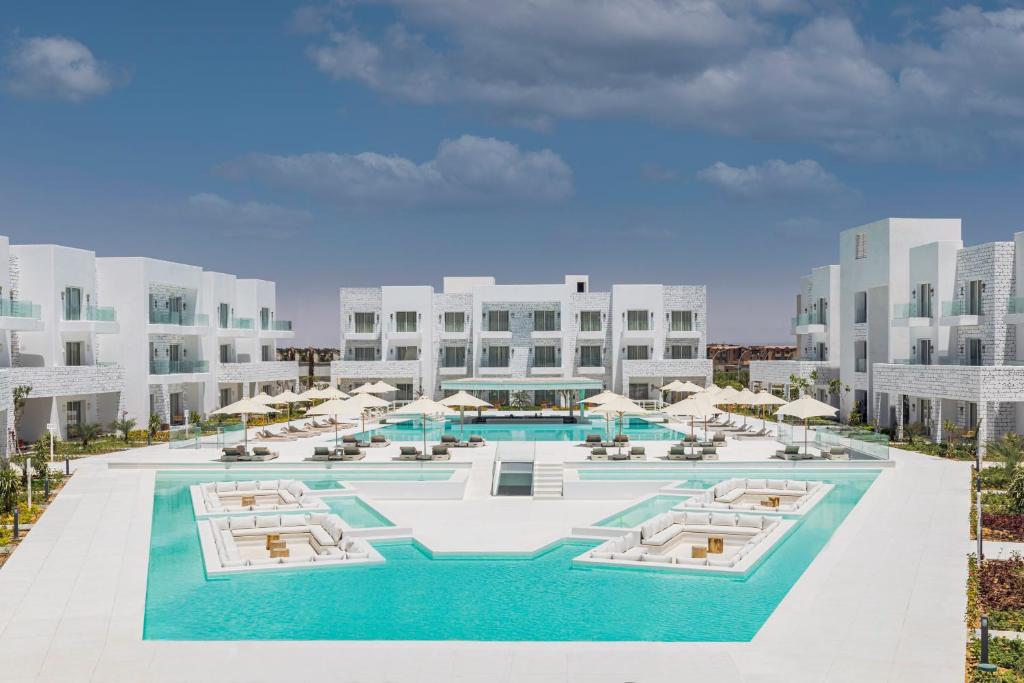 eine Luftansicht eines Resorts mit Pool und Sonnenschirmen in der Unterkunft Tanoak Resort in Ain Suchna