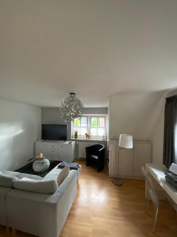 ein Wohnzimmer mit einem weißen Sofa und einem Tisch in der Unterkunft Susewind in Bad Segeberg