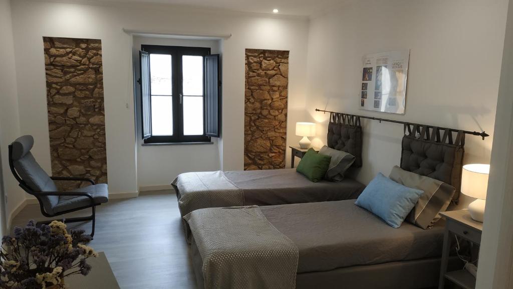 1 dormitorio con 2 camas y sofá en Pátio do Marquês - estadias de curta e média duração en Portalegre